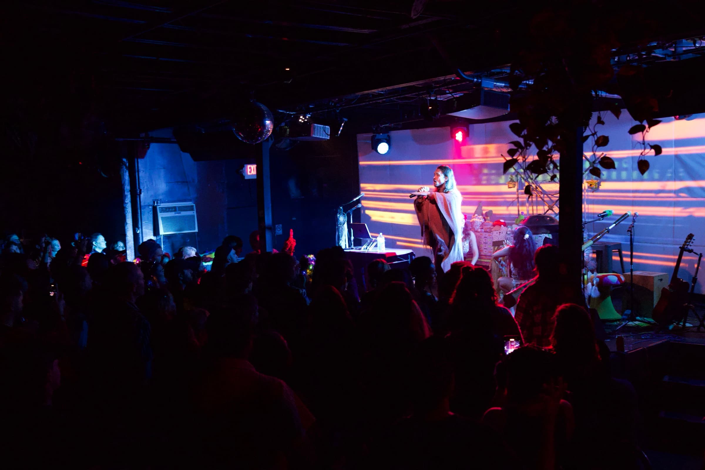 Daniel singing on a glowing stage, the crowd in silhouette in front of him